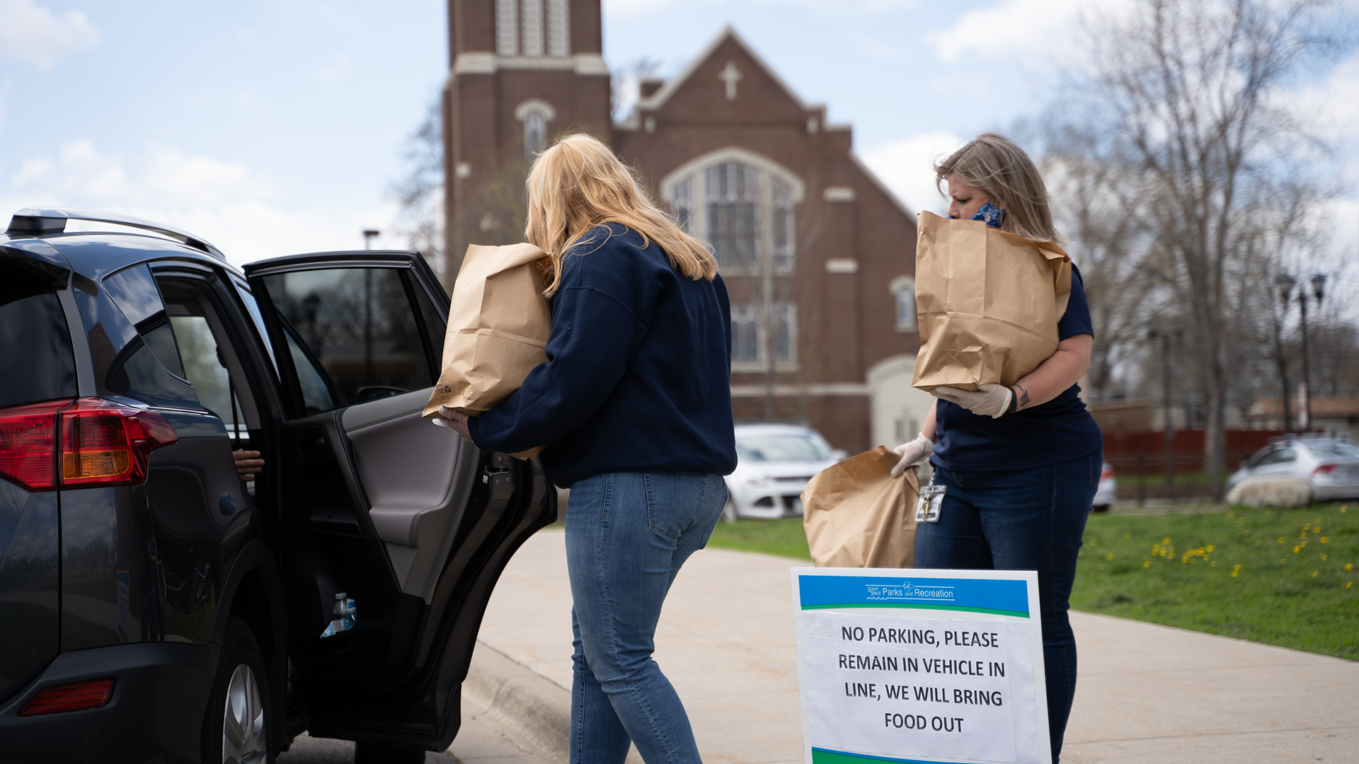 City staff distribute meals to residents at Arlington Hills Community Center