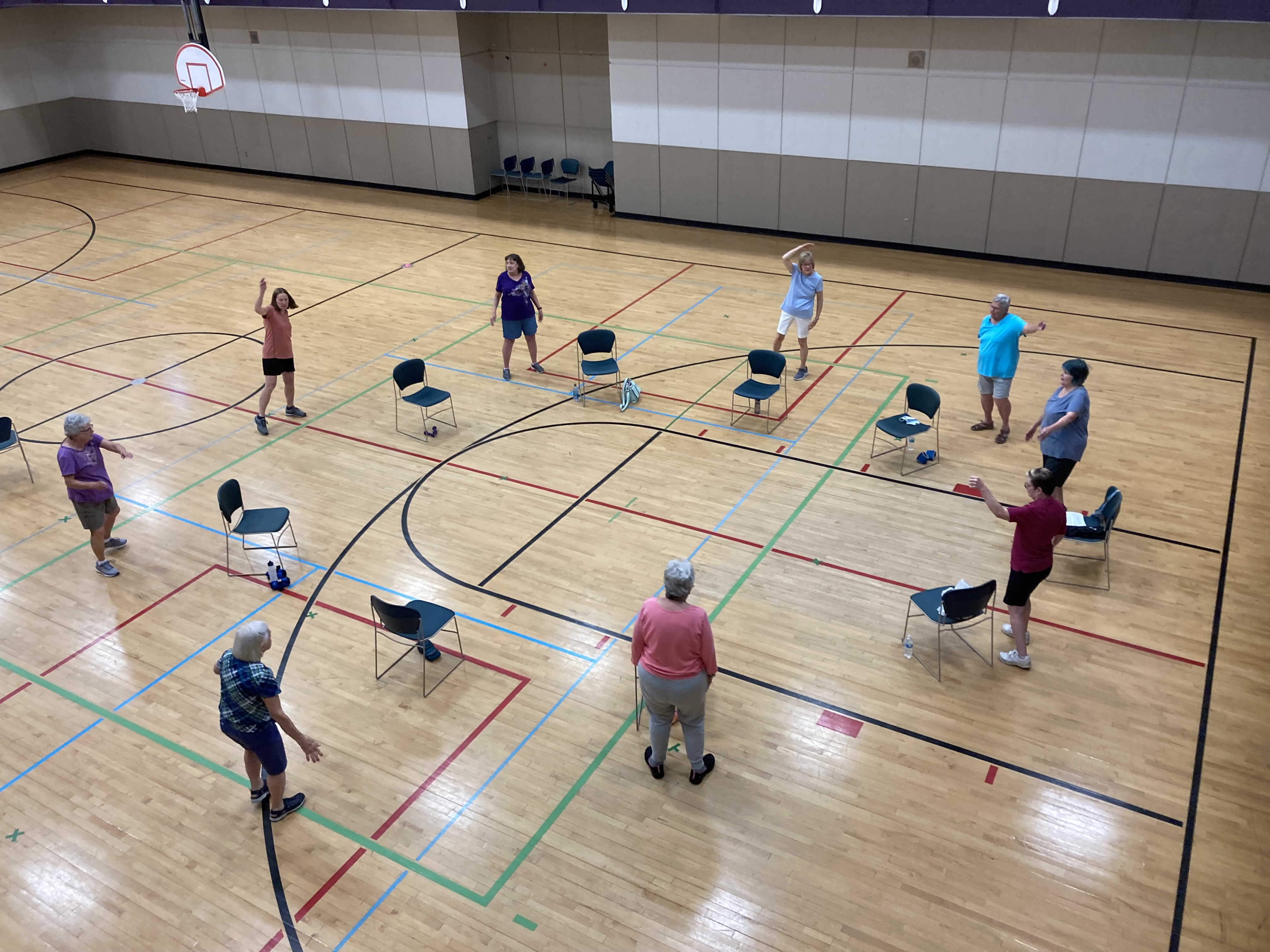 View from walking track of Senior Fitness class standing 6 feet apart