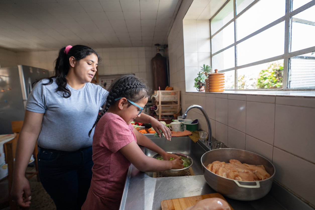 Woman and child washing dishes