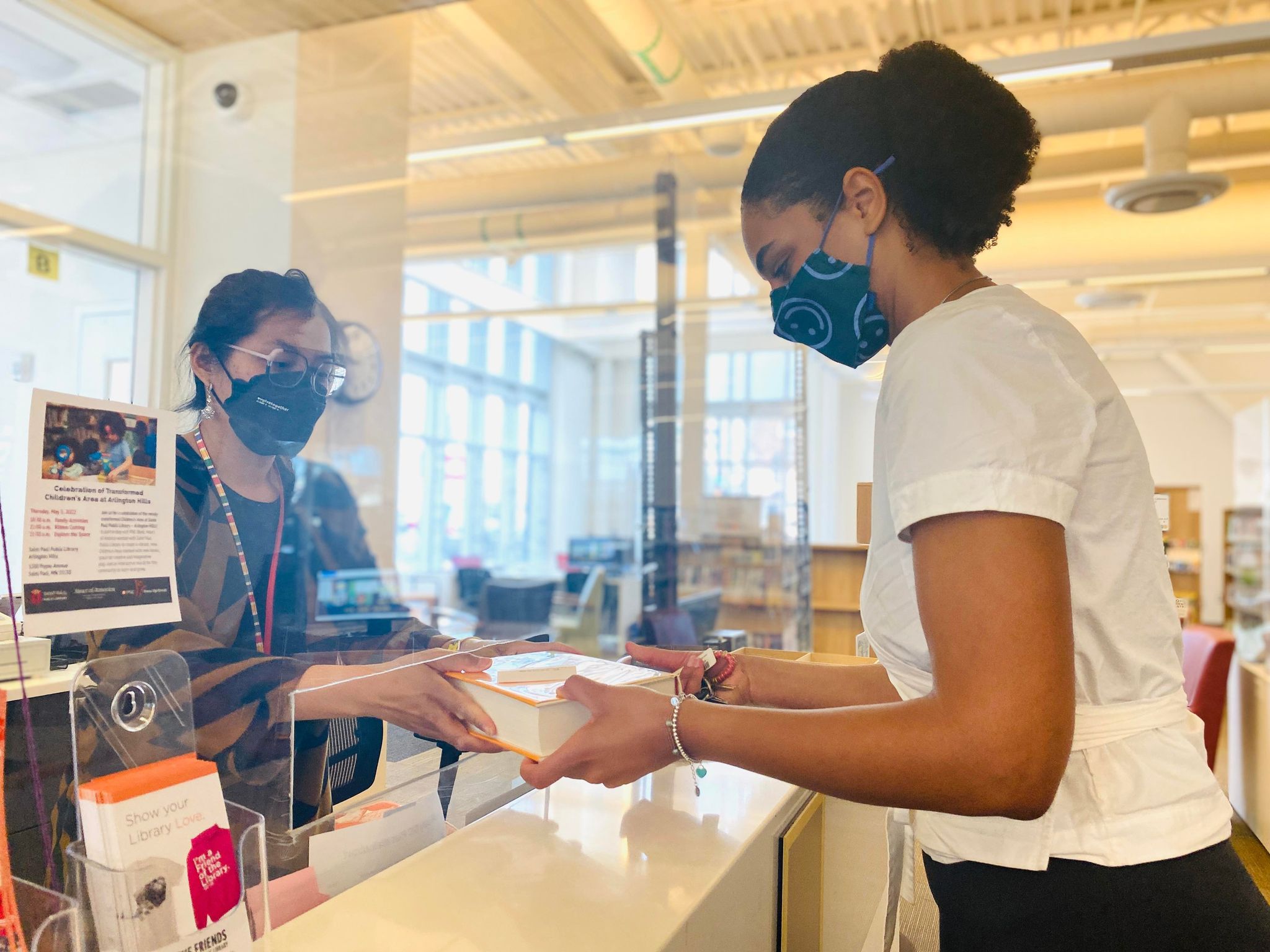 Person handing someone a library book