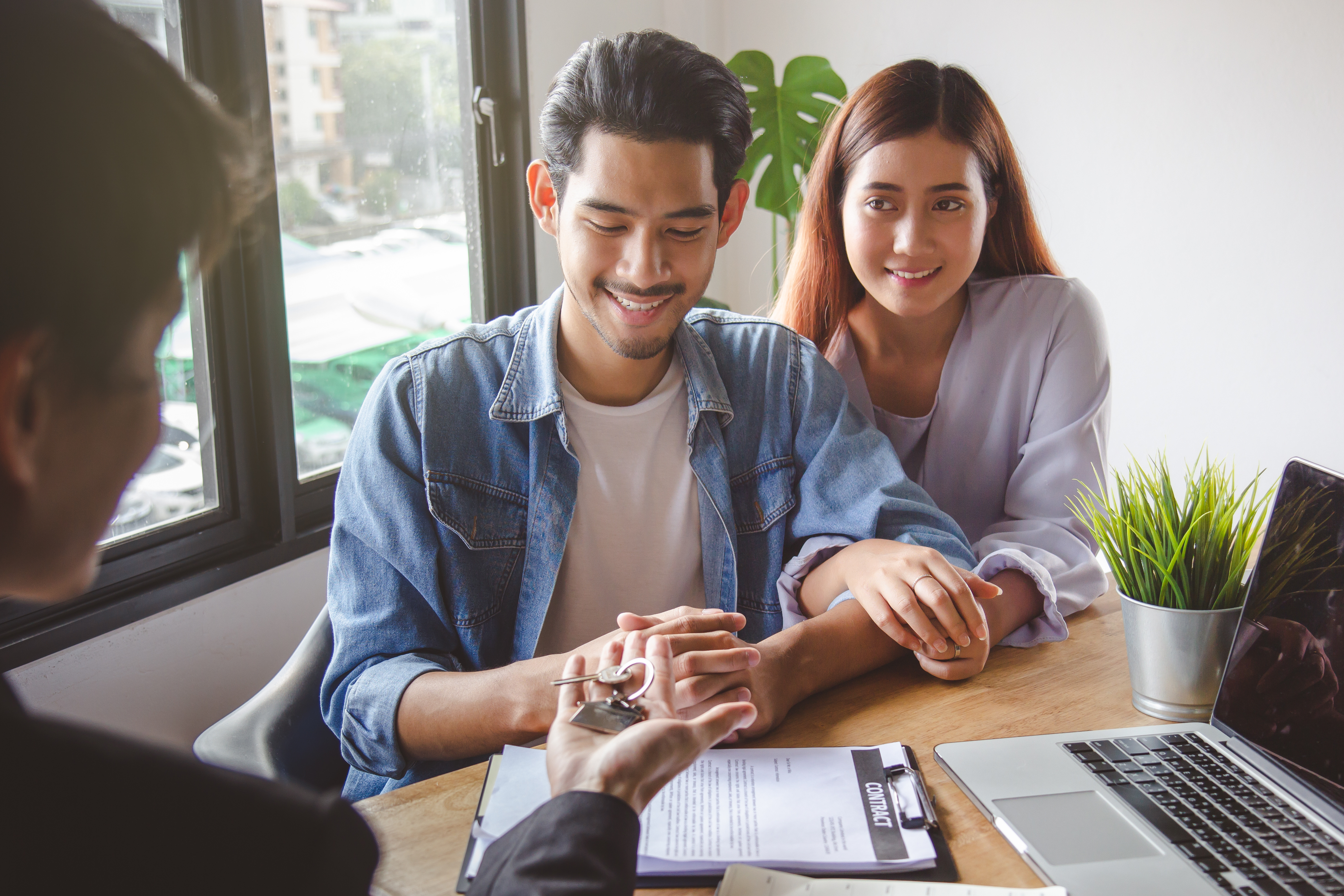 A young couple signing a lease document