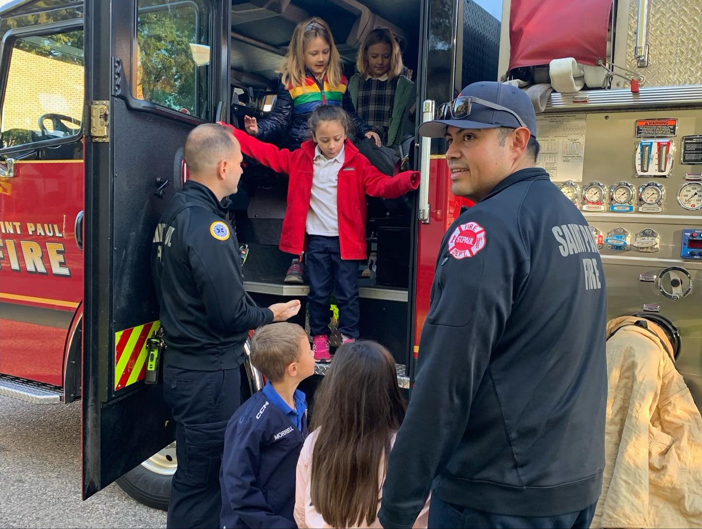 Firefighters helping children explore a fire truck at National Night Out