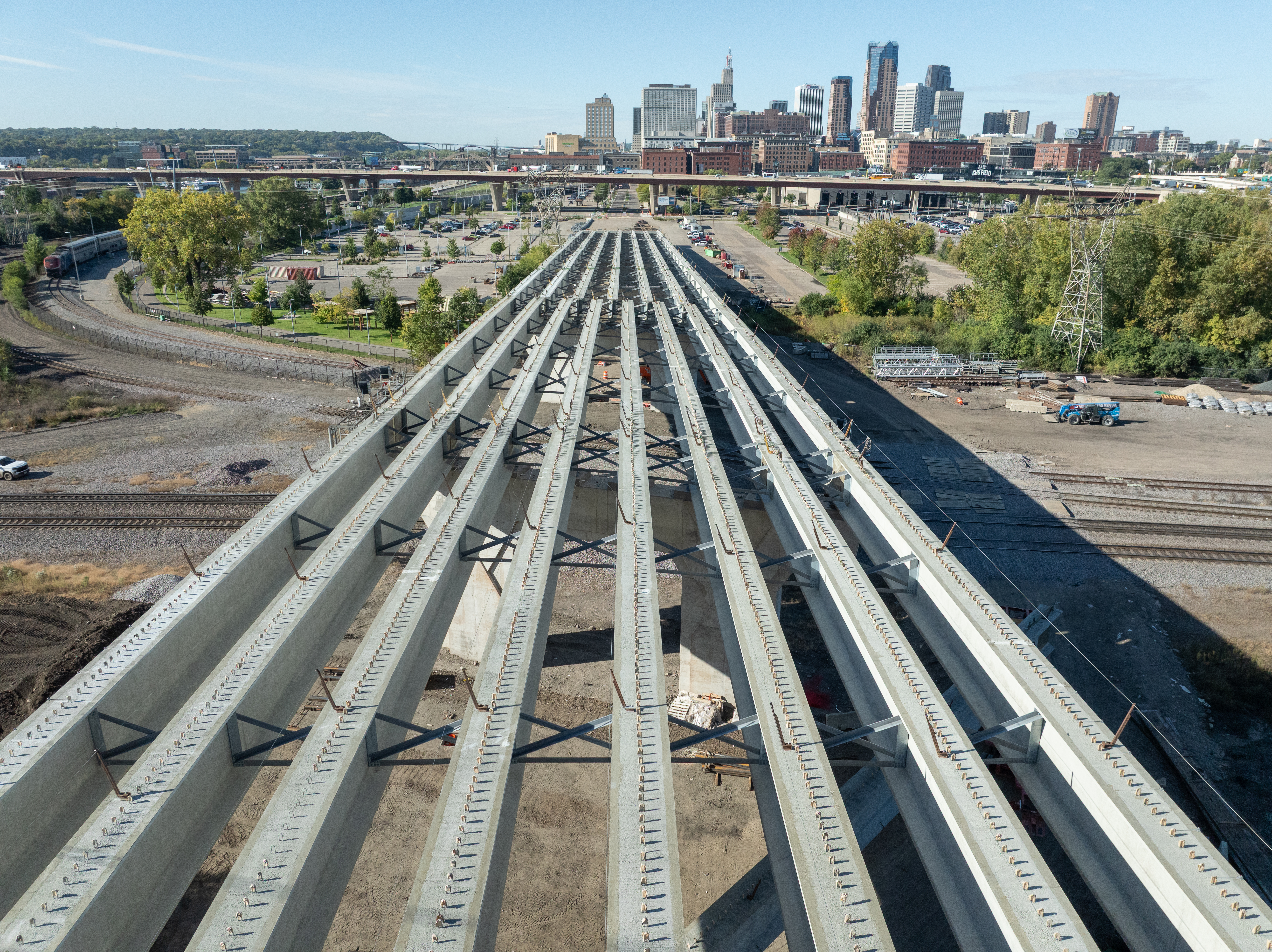Photo showing the new beams on the Kellogg-3rd Street bridge with blue sky and the downtown Saint Paul skyline in the background