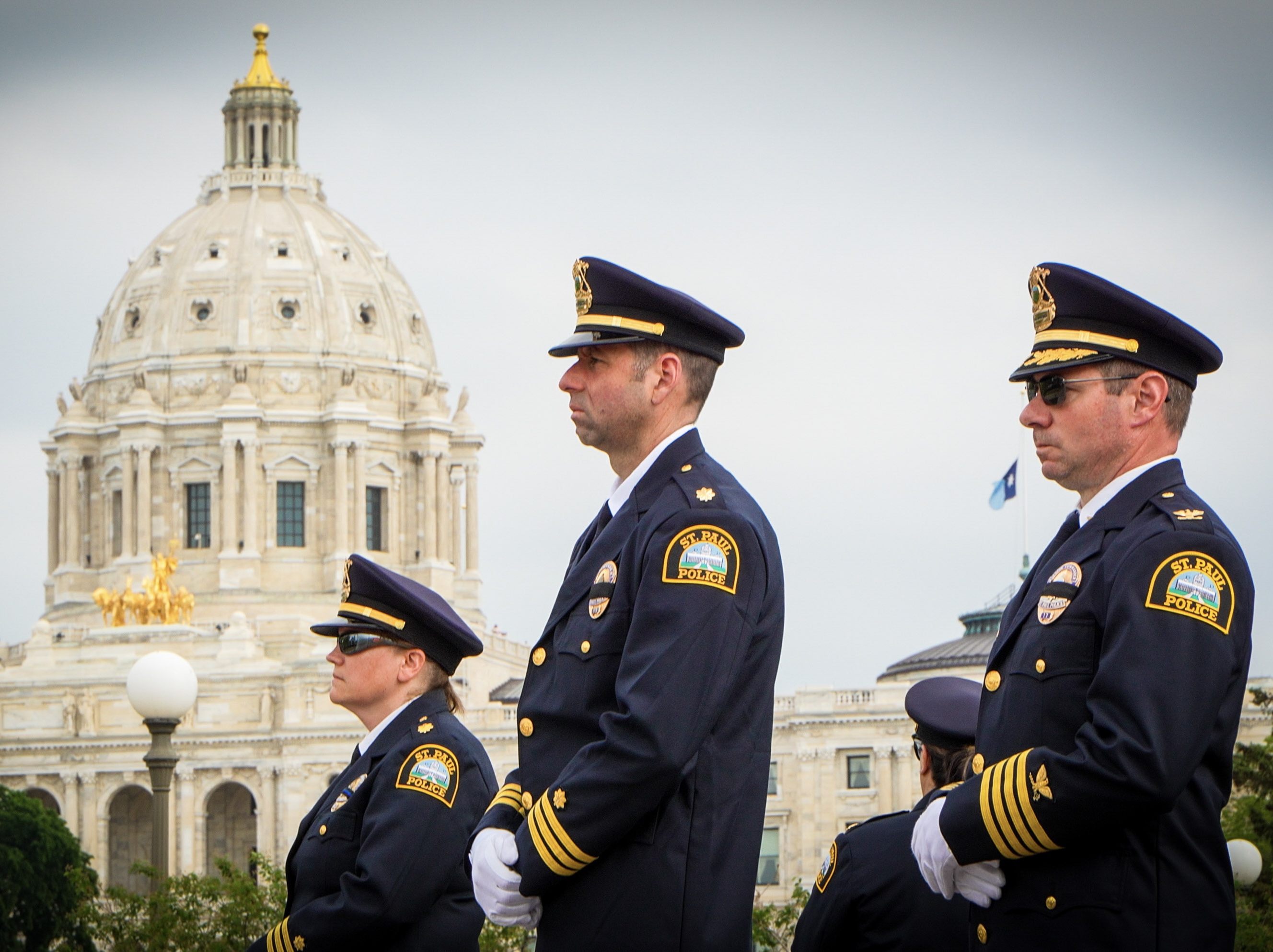 Saint Paul police officers stand in uniform at a ceremony outside the Minnesota state capitol.