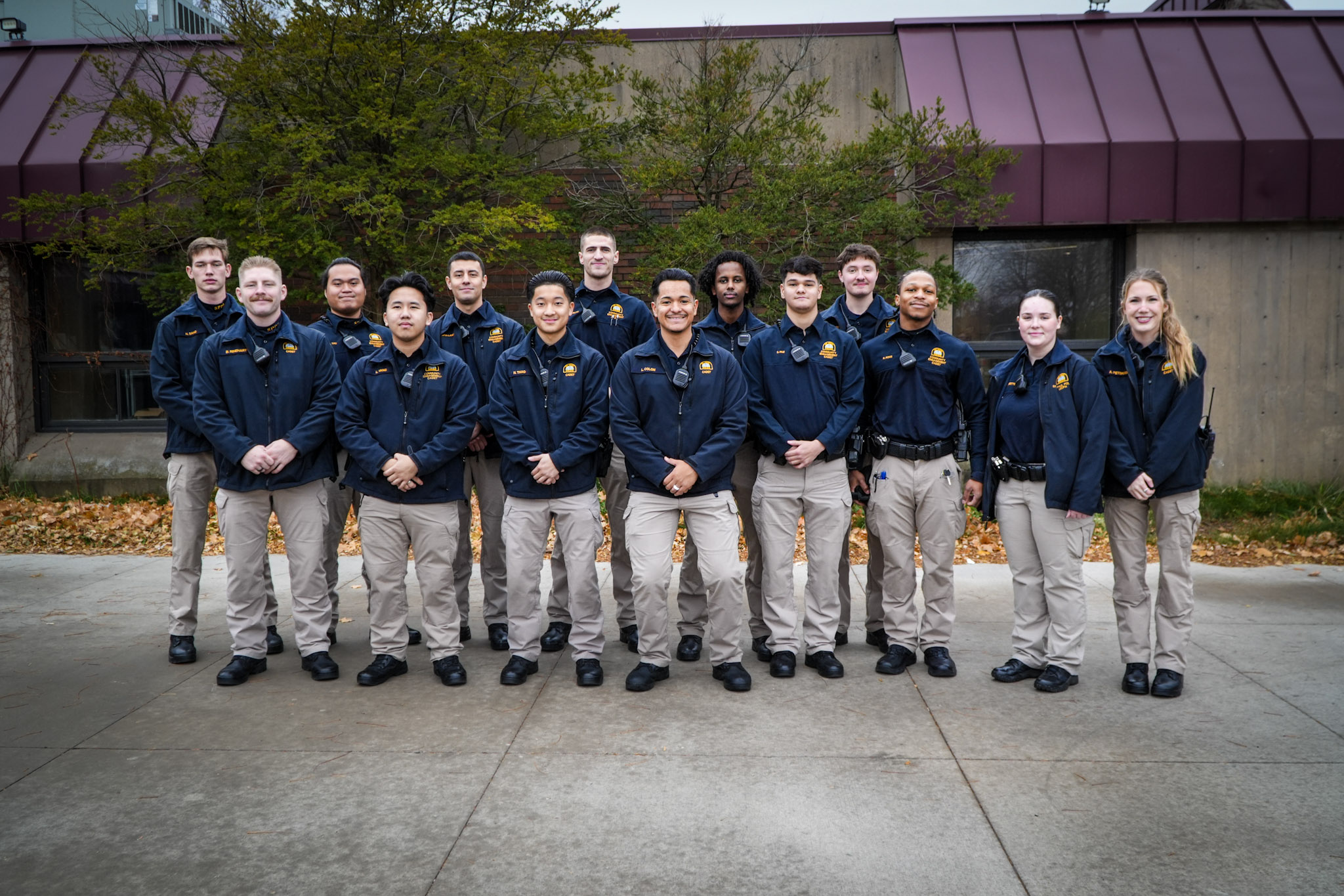 A dozen new cadets stand together in khakis and navy blue jackets.