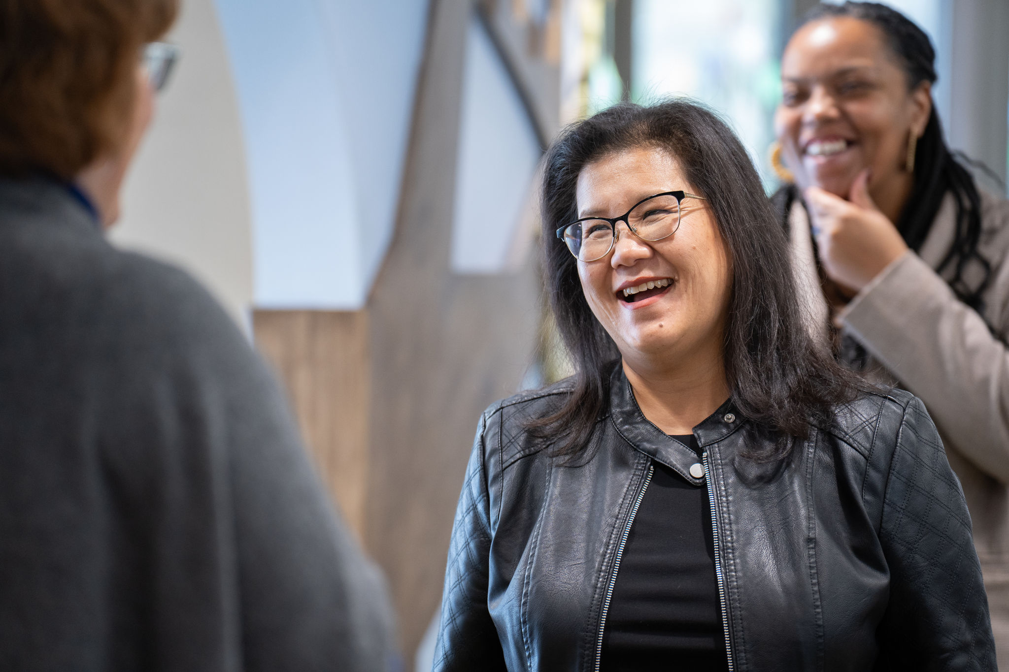 Mayor Her smiles while talking among a group of people.