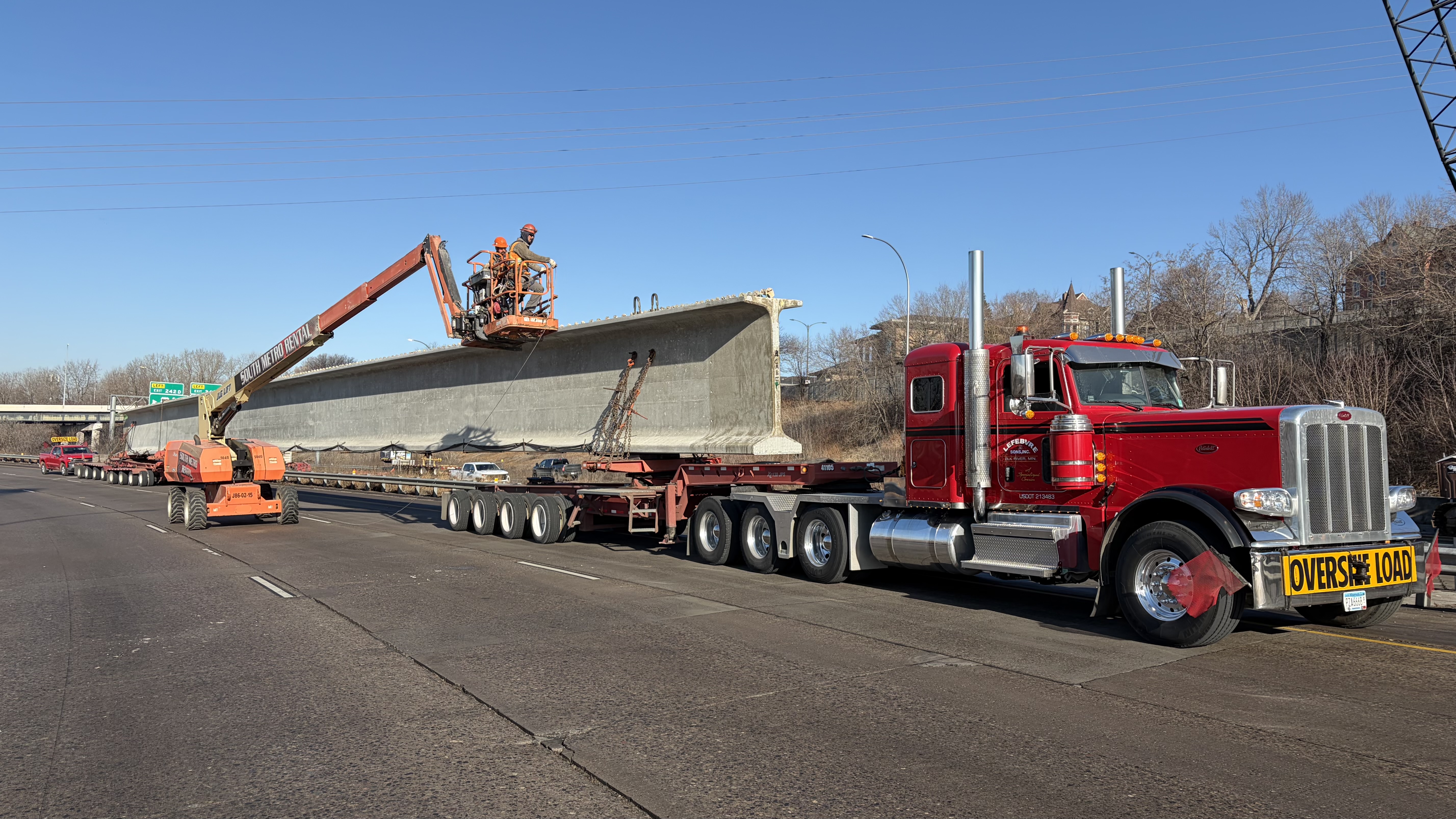 Bridge beam being unloaded from semi-truck on I-94 for installation on the Kellogg-3rd Street bridge.