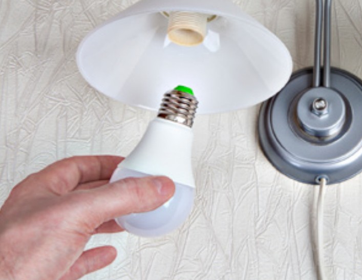 Hand changing a lightbulb