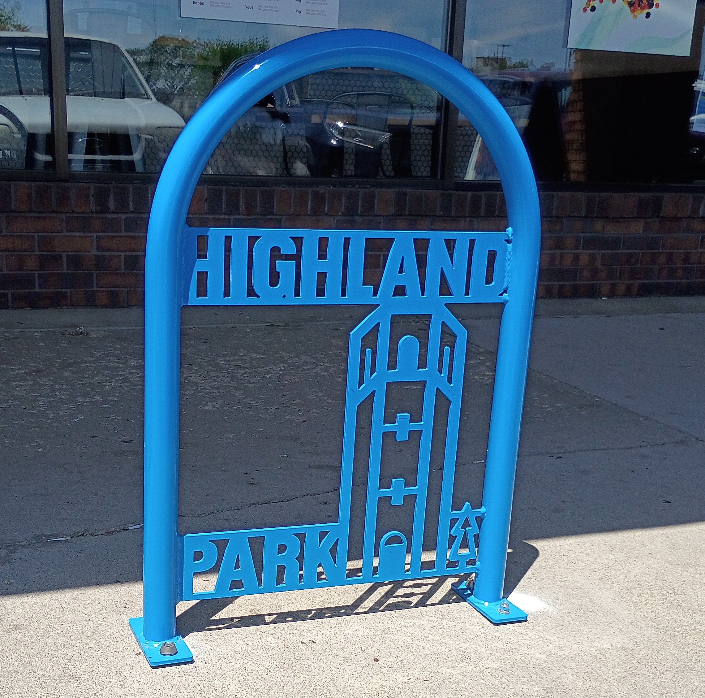 Blue "Highland Park" bike rack with a water tower cutout illustration.