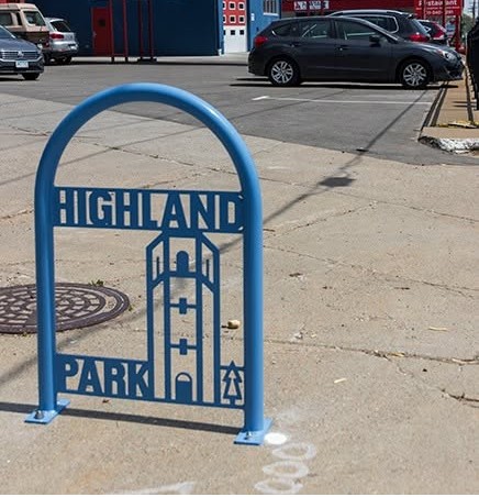Blue "Highland Park" bike rack with a water tower cutout illustration.