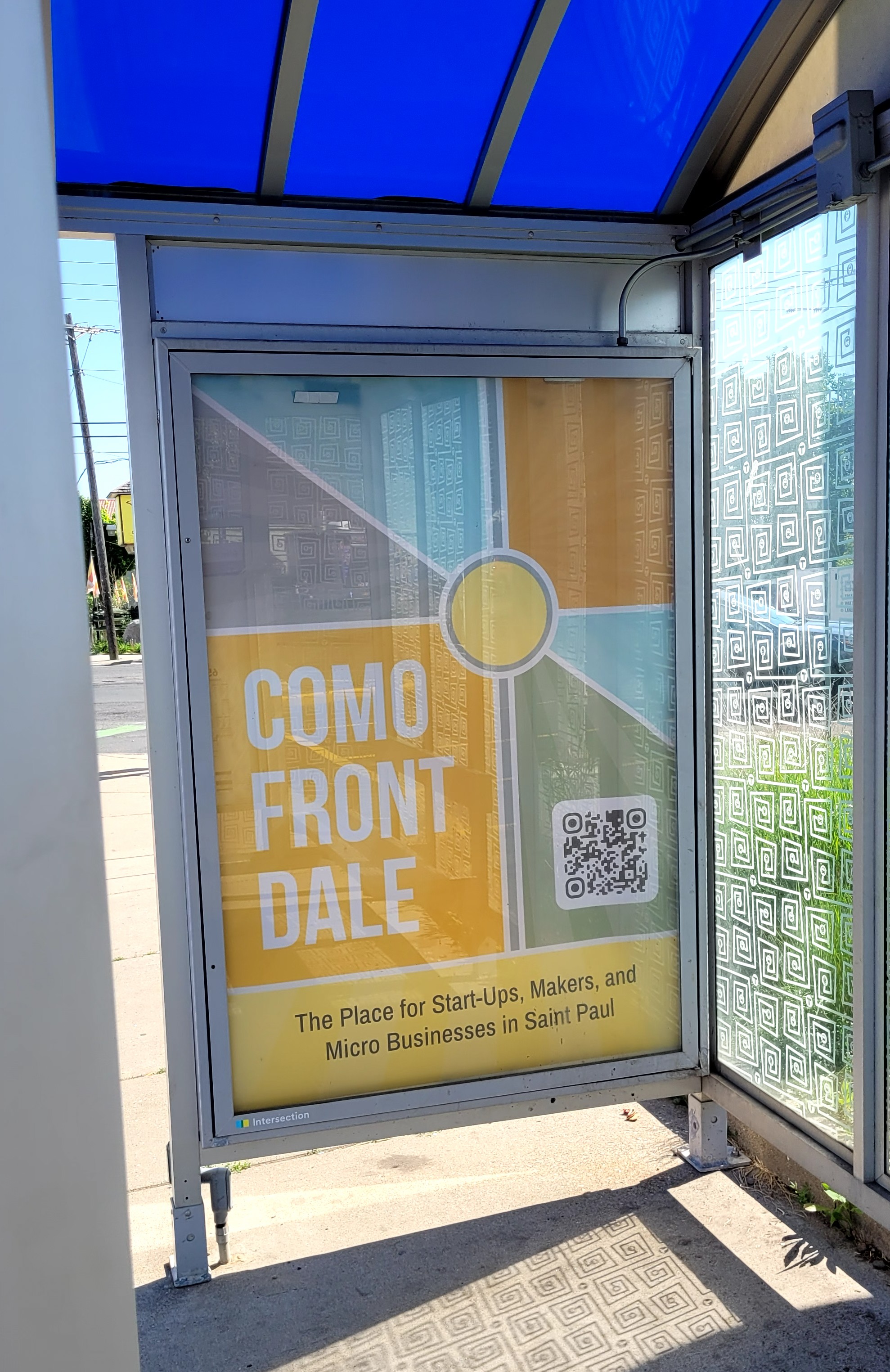 Como Front Dale district ad seen from inside a bus shelter.