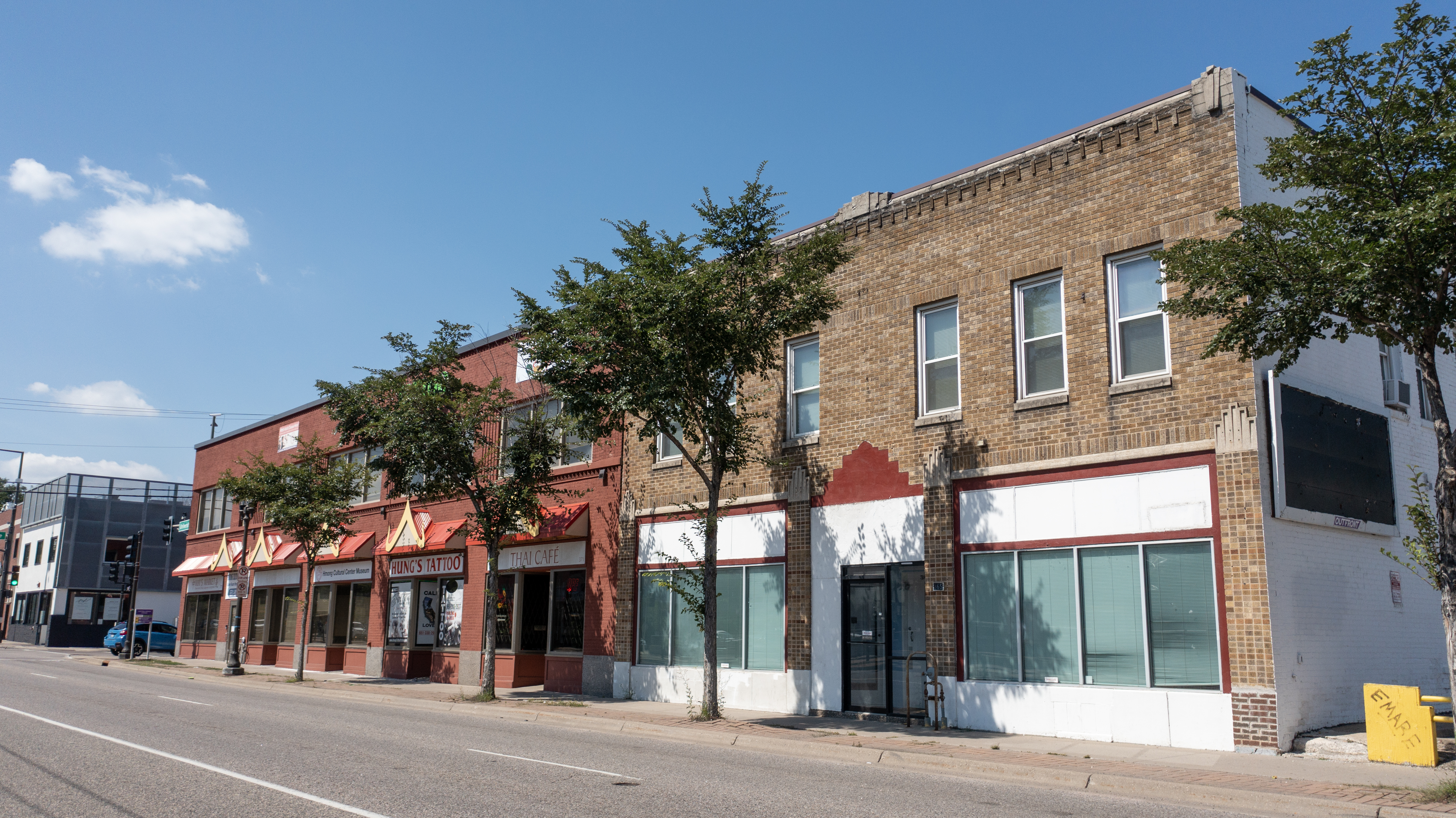 Brick storefronts along University Avenue including the Hmong Cultural Center Museum and Hung's Tattoo.