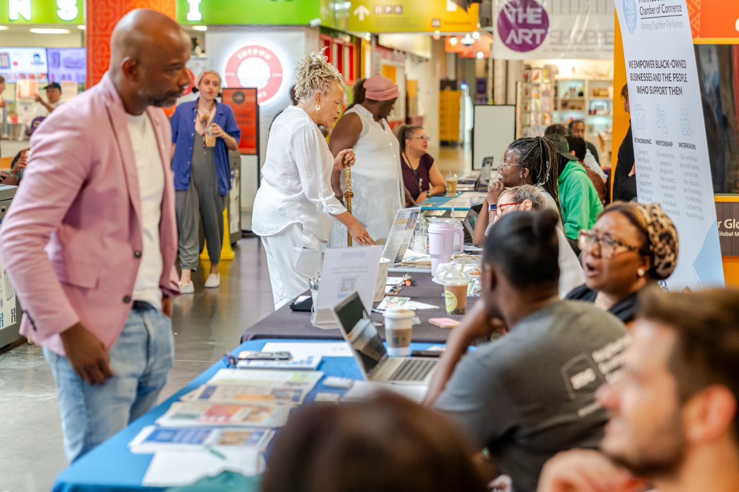 Attendees browse outreach tables and talk with staff at a Minnesota Black Chamber of Commerce tabling event.