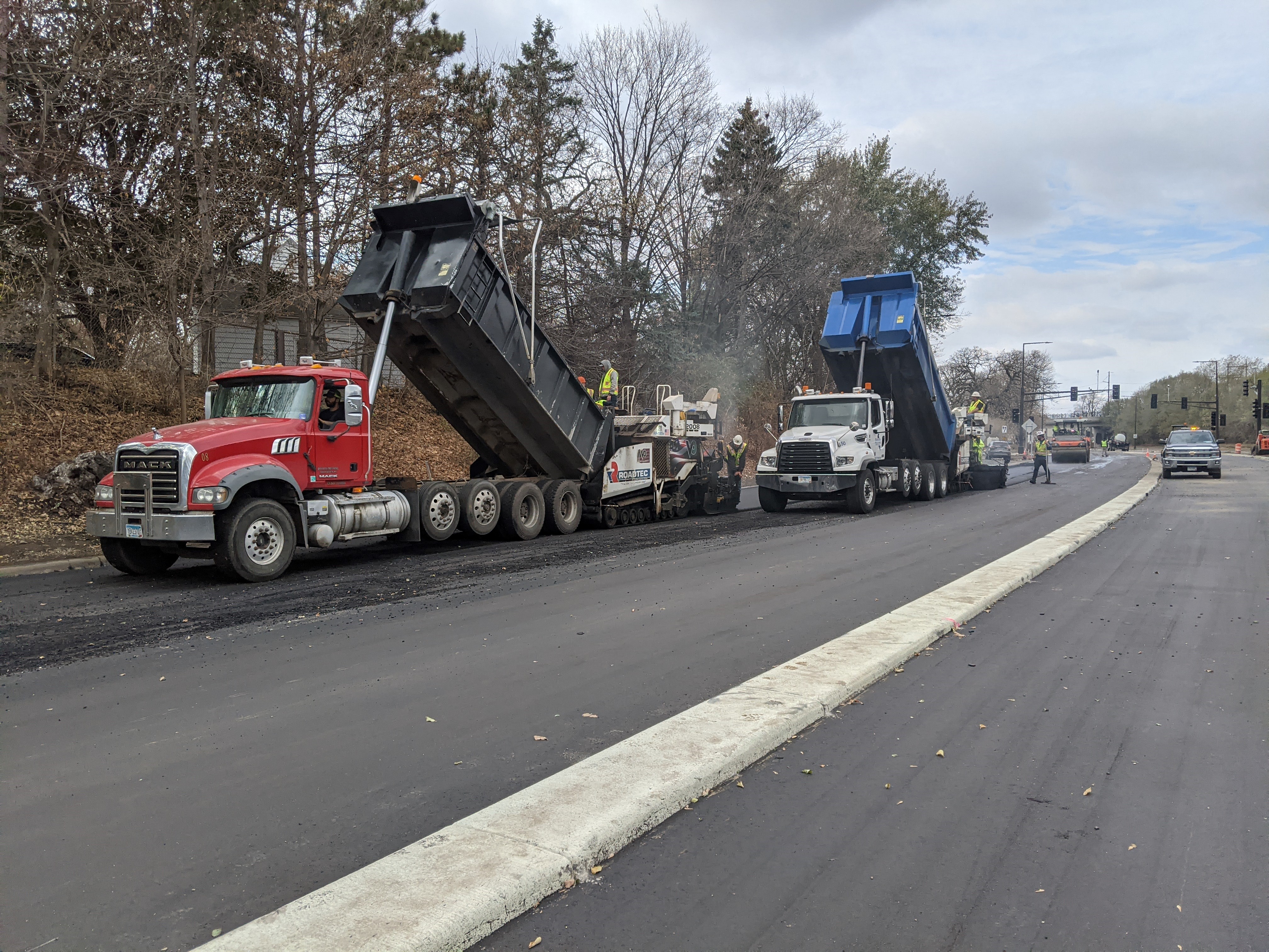 Construction photo of Ayd Mill Road from 11.2.20. Photo shows the view from northbound Ayd Mill Road between the Summit Avenue bridge and Ashland Avenue. In the photo, the contractor is paving southbound lanes of Ayd Mill Road using large equipment.