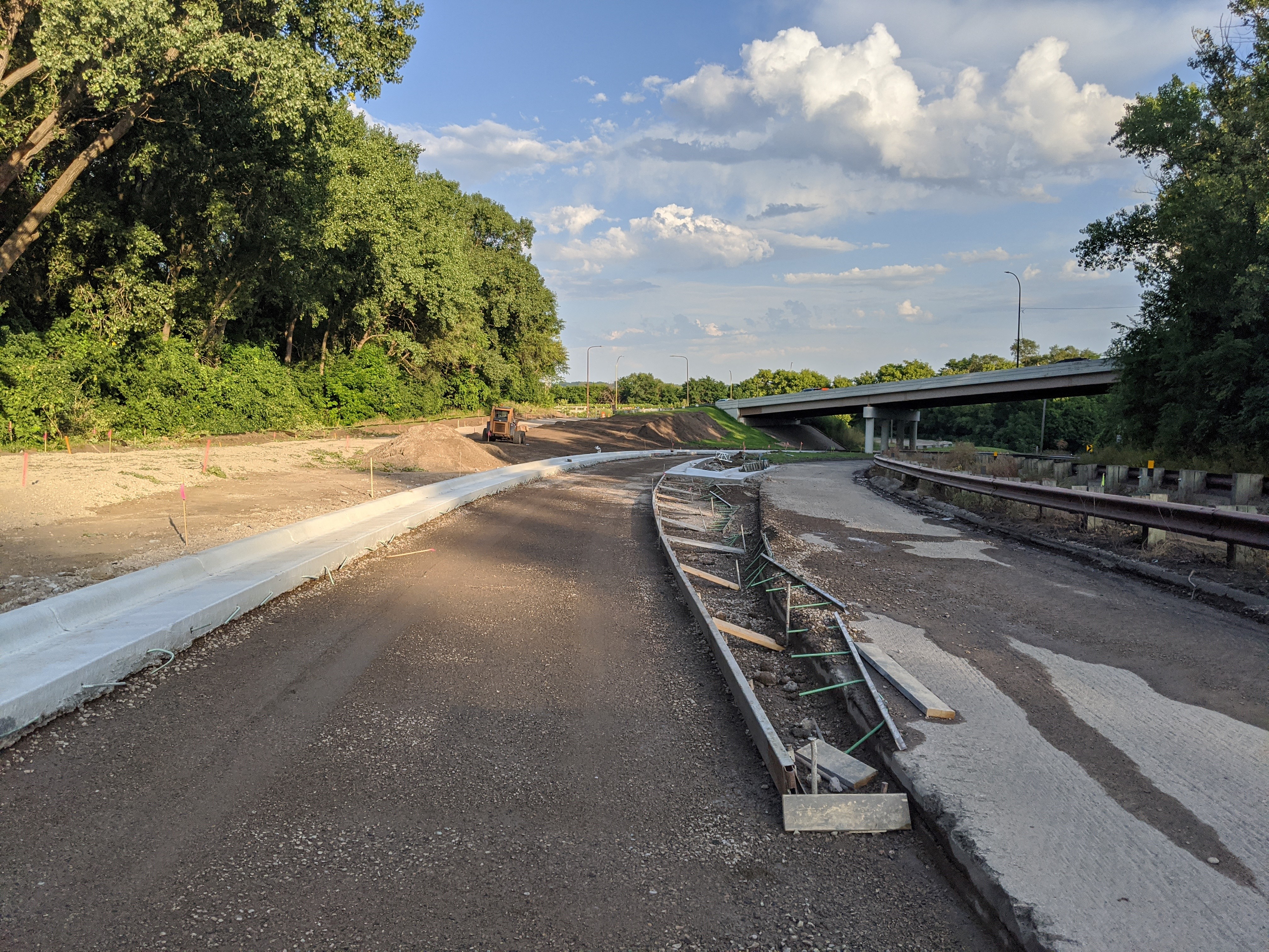 Ayd Mill Road construction photo. View of new curb at Jefferson Avenue ramp realignment. Overpass in background is Jefferson Avenue. Photo taken facing south east.