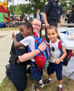 Police Officer and kids hugging at Safe Summer Nights Police Officer and kids hugging at Safe Summer Nights