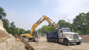 Excavator putting debris in back of dump truck