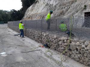 Contractors with wire cages building the gabion wall on Wabasha