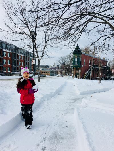 Girl walking along sidewalk on a snowy day