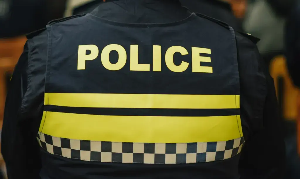 The back of a police vest with yellow letters spelling out, POLICE.