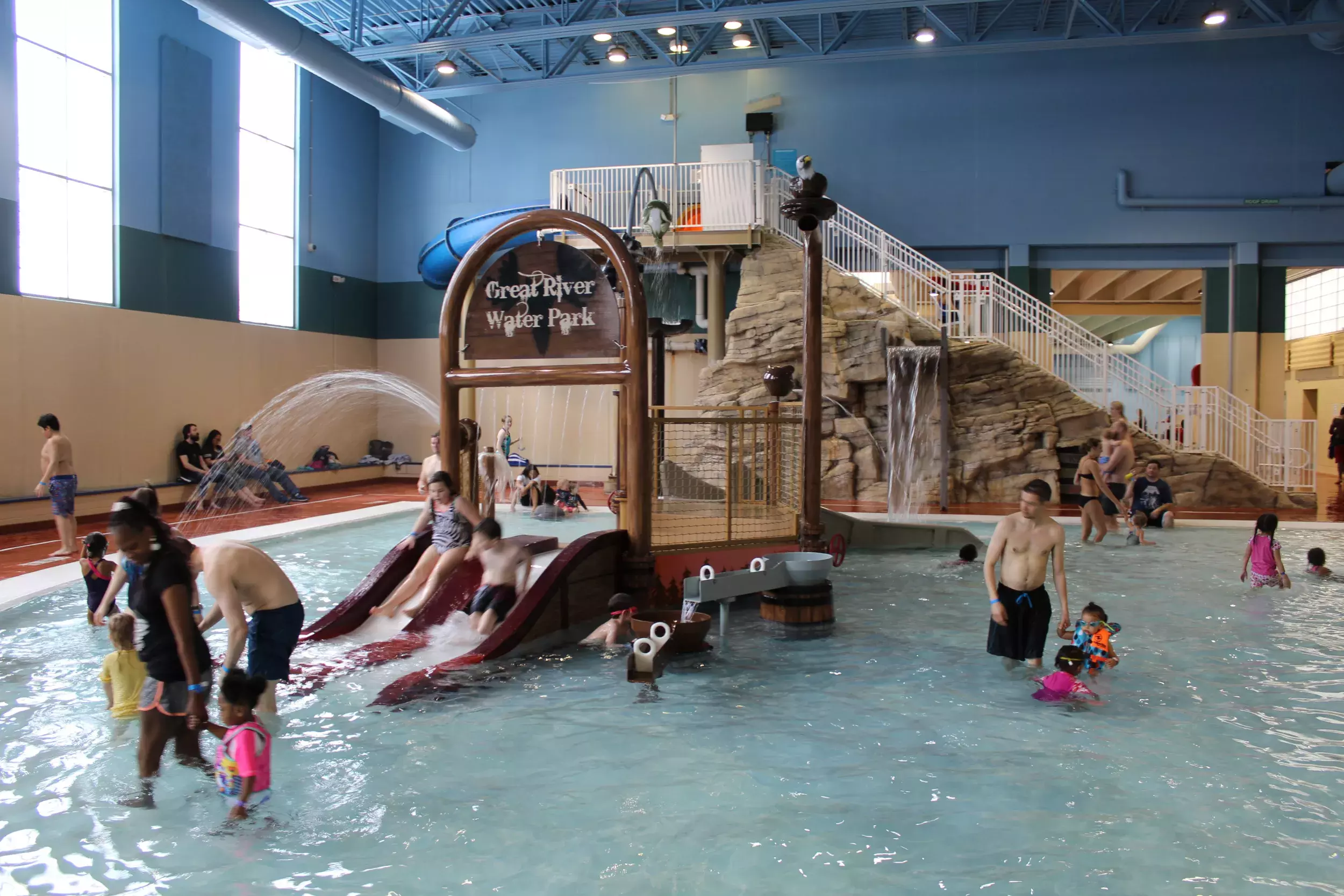 Children's splash pool with water slides and sign that reads "Great River Water Park ".