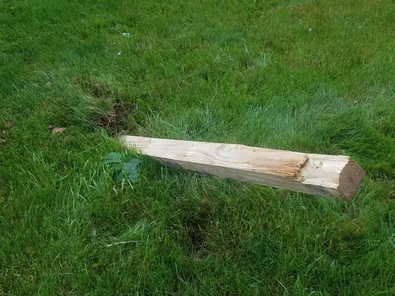 photograph of a 4x4 piece of lumber storm debris embedded into the ground