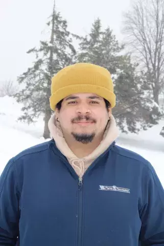 Photo of Nico in the winter wearing a yellow-orange beanie