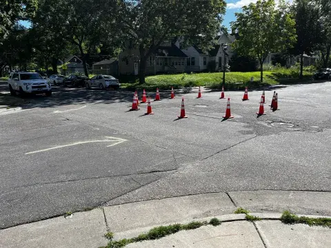 A photo showing a temporary neighborhood traffic circle set up at Rose and Park intersection. Orange cones. 
