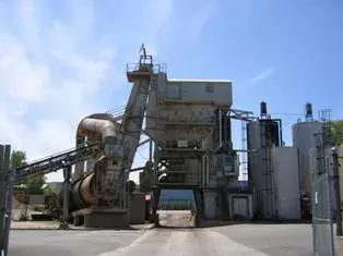 Image of the City of Saint Paul's asphalt batch plant with a truck receiving a load of asphalt underneath it.