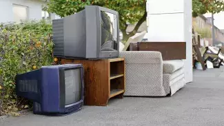Televisions, couch, furniture and a refrigerator out for collection.