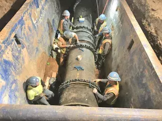 Six construction workers installing a 36" ductile iron pipe