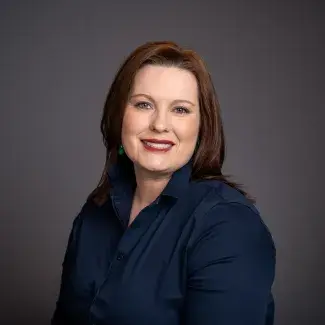 Deputy Mayor Tincher - 2025 A smiling woman with light skin and dark brown hair, wearing a dark blue long sleeve blouse.