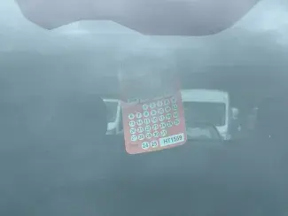 Close up of car windshield with orange Saint Paul residential permit parking one-day hang tag