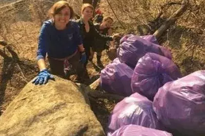 Group outside next to bags of litter they collected