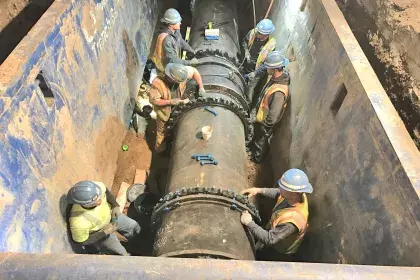 Six construction workers installing a 36" ductile iron pipe