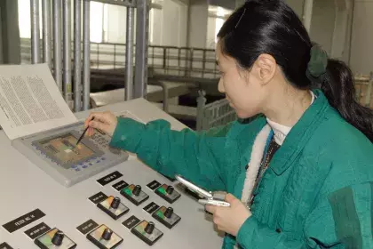Woman using a stylus to interact with the screen of a water filter control panel