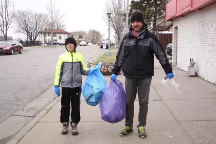 a man and boy holding bags of litter that they collected