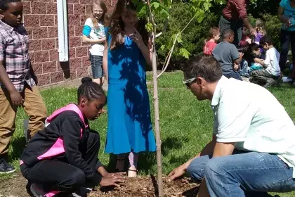 Adult and child plant a tree on Arbor Day
