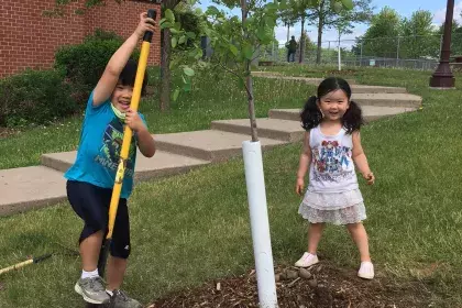 Two children planting a tree on Arbor Day