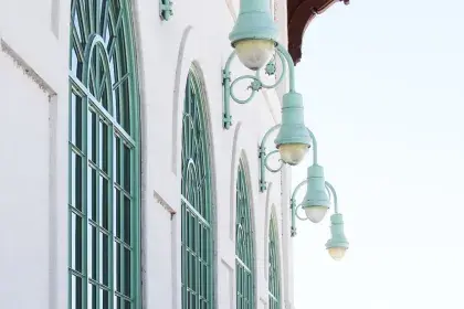 Close up of the front of the Como Lakeside Pavilion. Row of large windows with light green trim and metal lamps hanging above them,