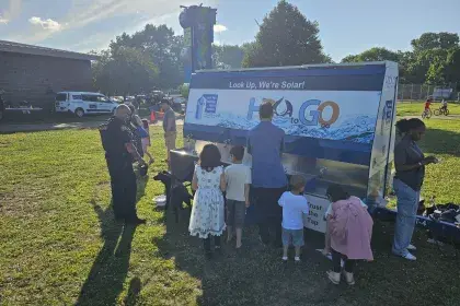 Community members and city staff grab ice cold water from SPRWS Water Wagon