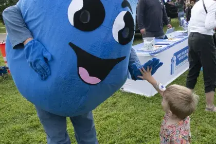SPRWS mascot Willy Water greets child with a high five at community event