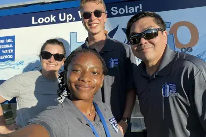 Four SPRWS staffers pose at sunny community event