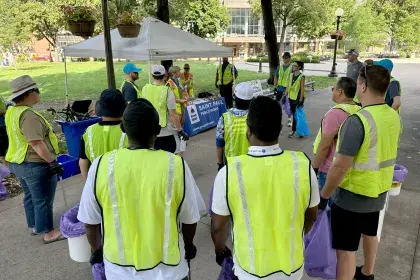 Litter cleanup volunteers gathered and listening to instructions before cleaning litter