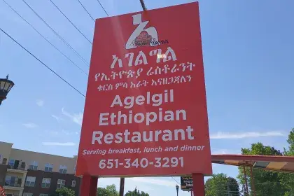 Red sign for Agelgil Ethiopian Restaurant with Amharic script and a woven basket logo.