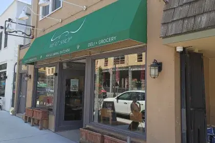 Butcher shop and deli storefront with a green awning.