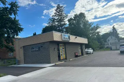 Exterior photo of Taste of Nepal restaurant, a single-story commercial building with menu-photo panels flanking the front door.