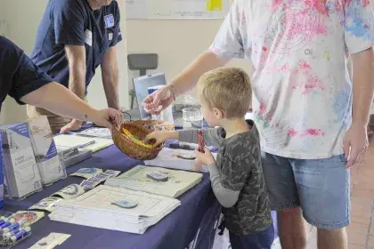 Kid reaches for candy at 2025 Highland Water Tower Open House event