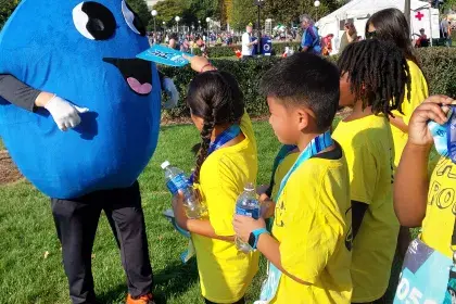 SPRWS Mascot Willy Water poses with kids at 2025 Twin Cities Marathon Mascot Race 