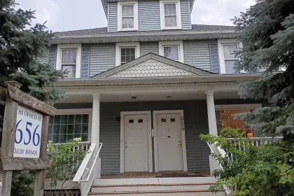 The Offices at 656 Selby Avenue, a three-story blue historic house converted to office space, with a wooden signpost identifying the address.
